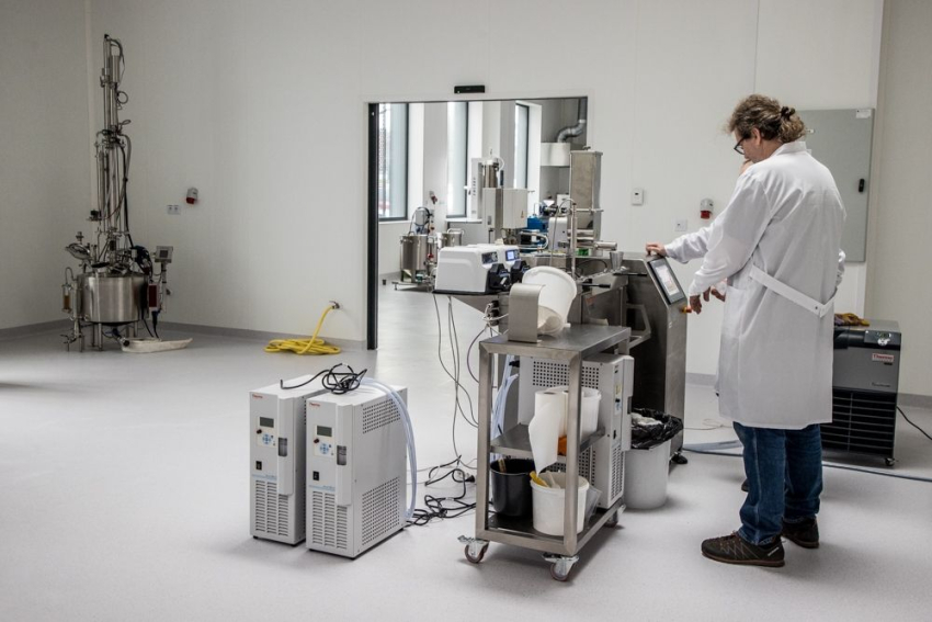 Mężczyzna w kitlu stoi przy sprzęcie w laboratorium.