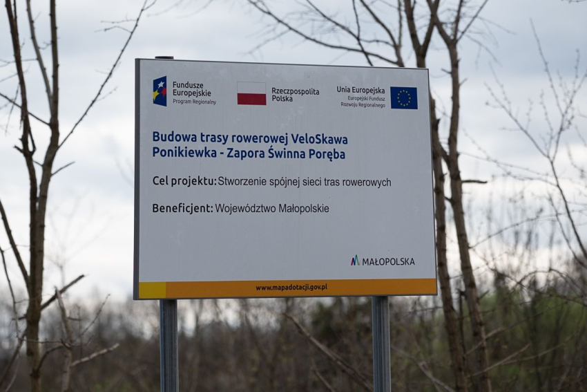 Tablica z informacją na temat nowo otwartej trasy rowerowej.