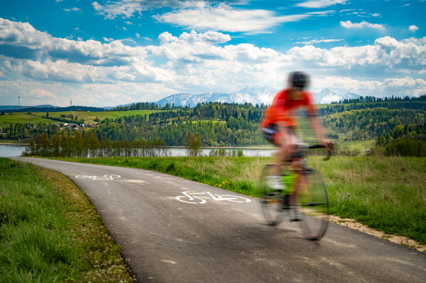 Rowerzysta jadący ścieżką rowerową dookoła jeziora.