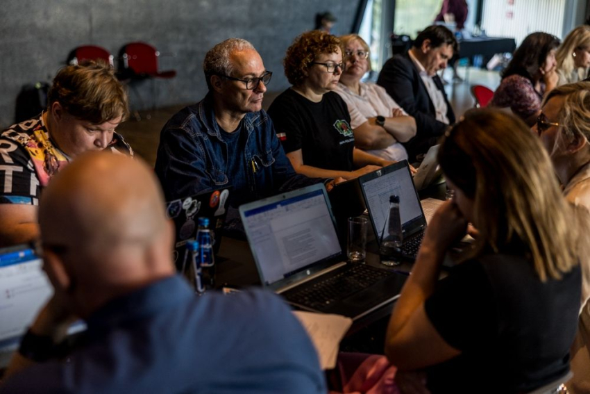 Członkowie posiedzenia przy laptopach.