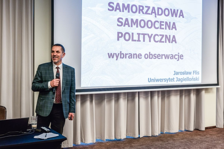 Mężczyzna stoi przy ekranie projektora