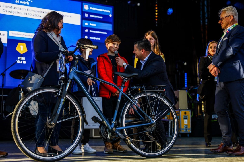 Marszałek Małopolski wręcza chłopcu nagrodę w postaci roweru.