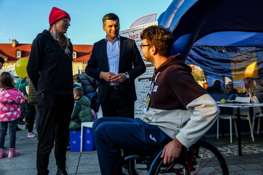 Marszałek Małopolski rozmawia z mężczyzną na wózku.