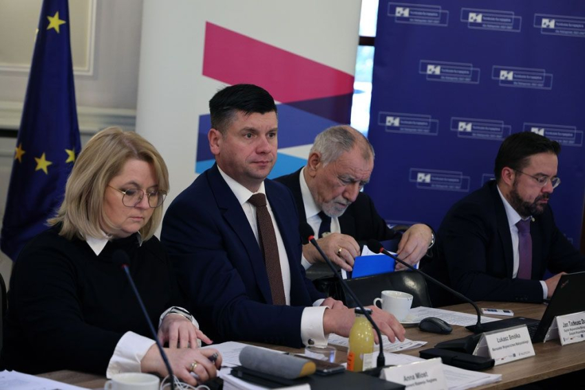 Marszałek Małopolski wraz z uczestnikami spotkania przy stole konferencyjnym.