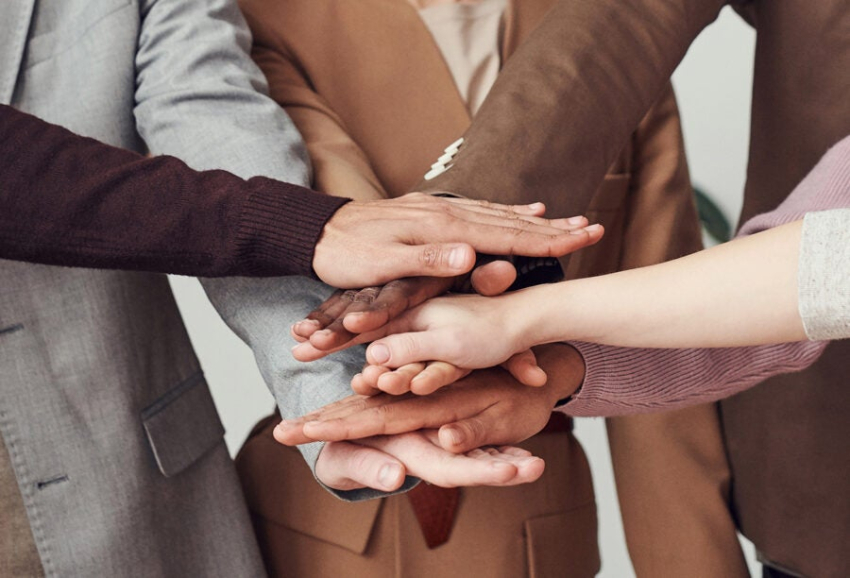 Ręce ułożone jedna na drugiej w geście partnerstwa.