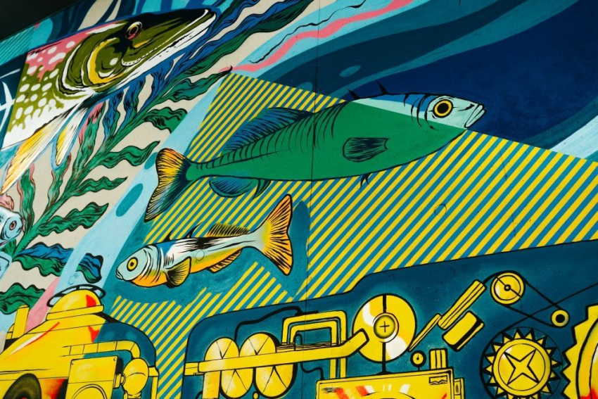 Mural przedstawiający ryby pływające wokół łodzi podwodnej.