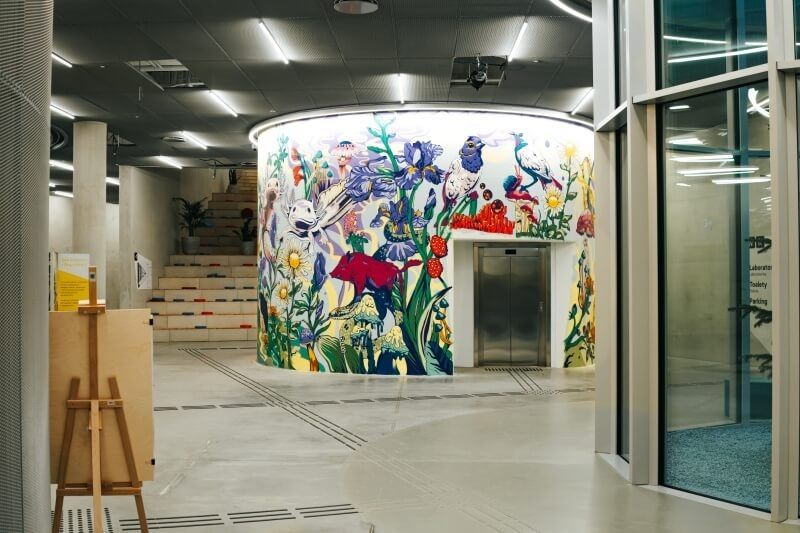 Hol budynku Cogiteon z widocznym muralem.