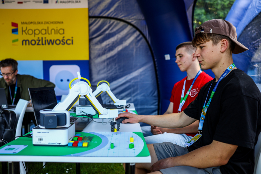 Dwóch nastolatków przy stole z nowoczesnymi robotami.