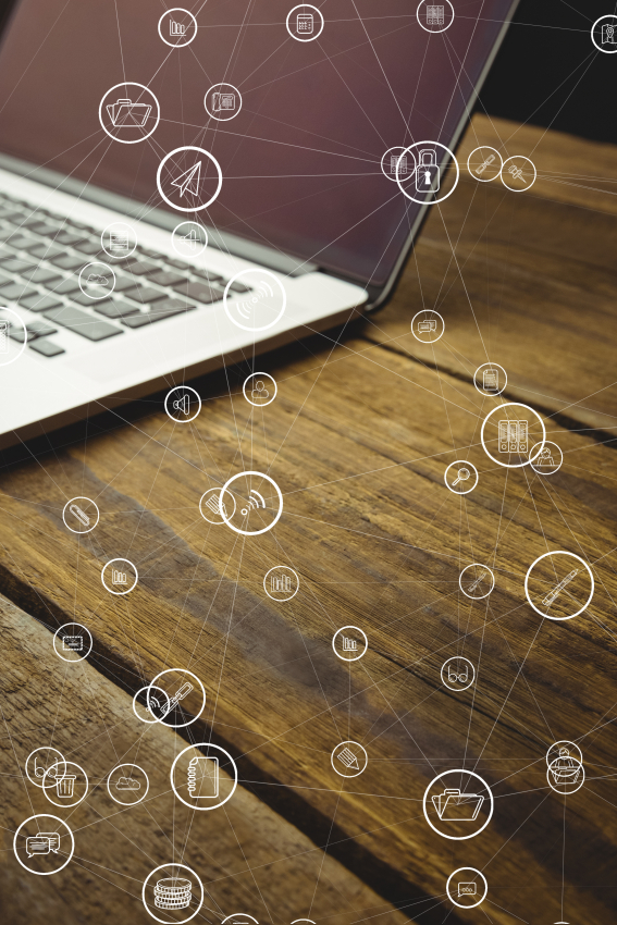 Fragament laptopa na biurku z wirtualnymi ikonkami telefonicznymi w tle.