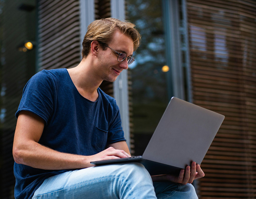 Młody chłopak pracuje na laptopie