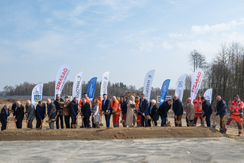 Uczestnicy wydarzenia wbijają symbolicznie łopaty w ziemię.