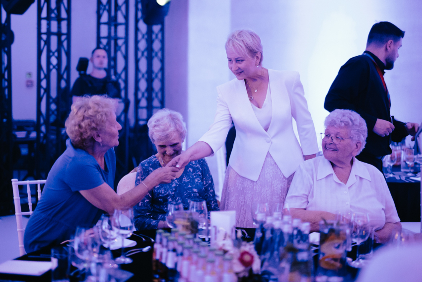 Członek zarządu Iwona Gibas wita się z seniorkami obecnymi na gali.