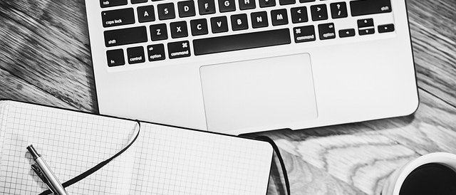 Widok z góry na klawiaturę laptopa i notatnik