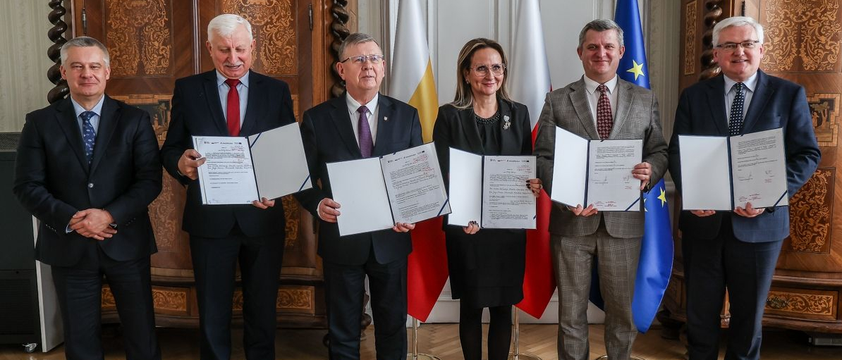 Uczestnicy spotkania prezentują podpisane umowy