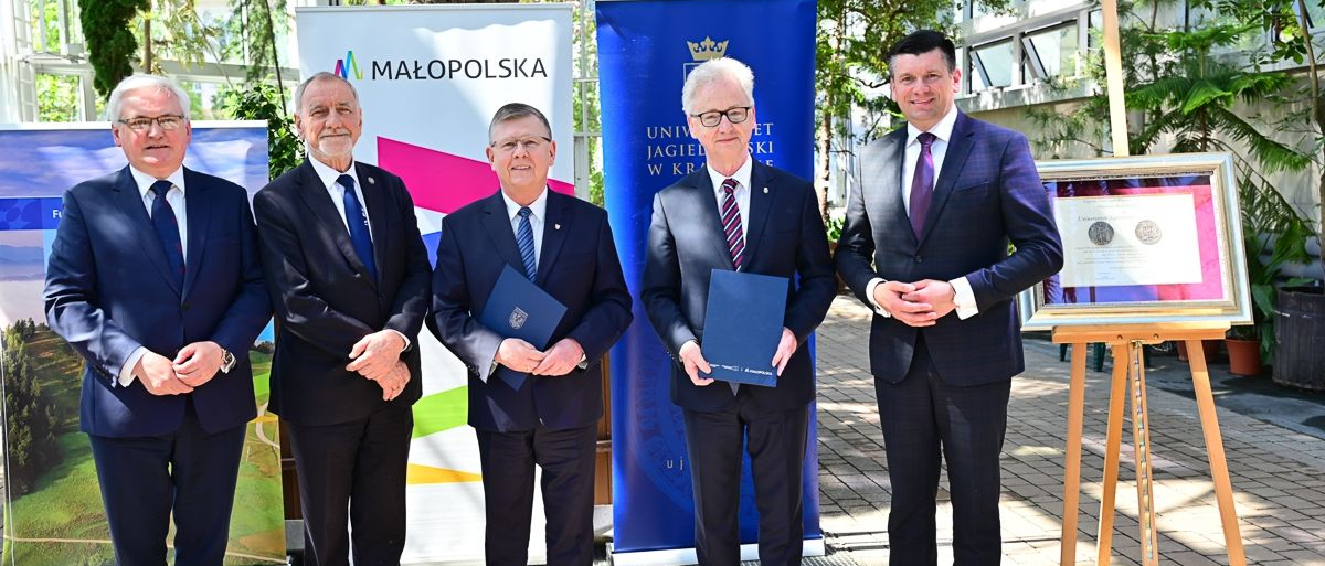 Pięciu mężczyzn w garniturach stoi w budynku ogrodu botanicznego.