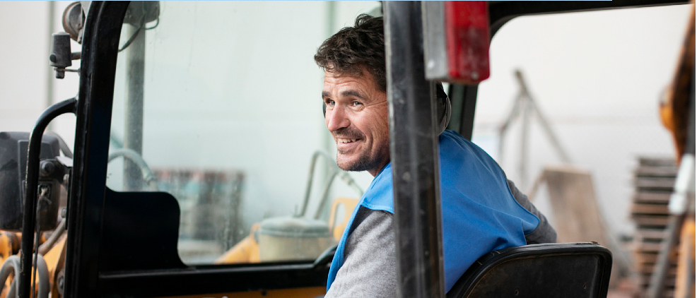 Mężczyzna za sterami wózka widłowego.