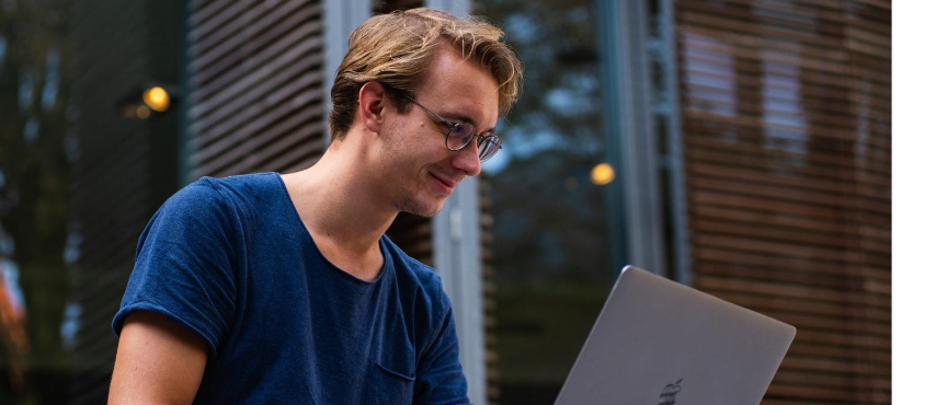 Młody chłopak pracuje na laptopie.