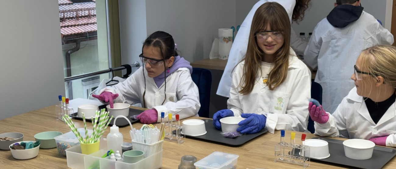 Dziewczynki robią eksperymenty przy stole.