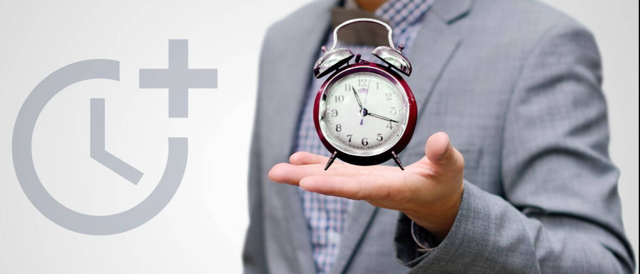 Mężczyzna trzymający w ręku budzik