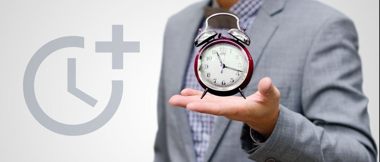 mężczyzna trzymający w dłoni budzik