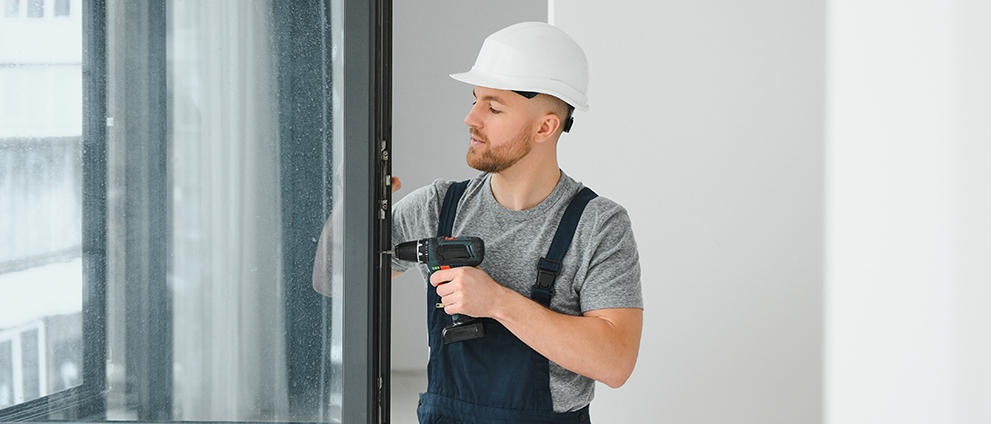 Mężczyzna uszczelnia okna.
