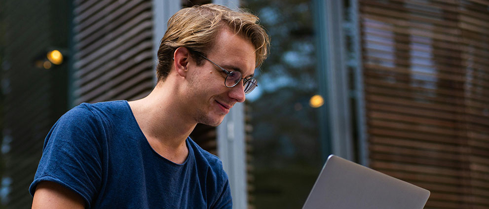 Młody chłopak pracuje na laptopie.