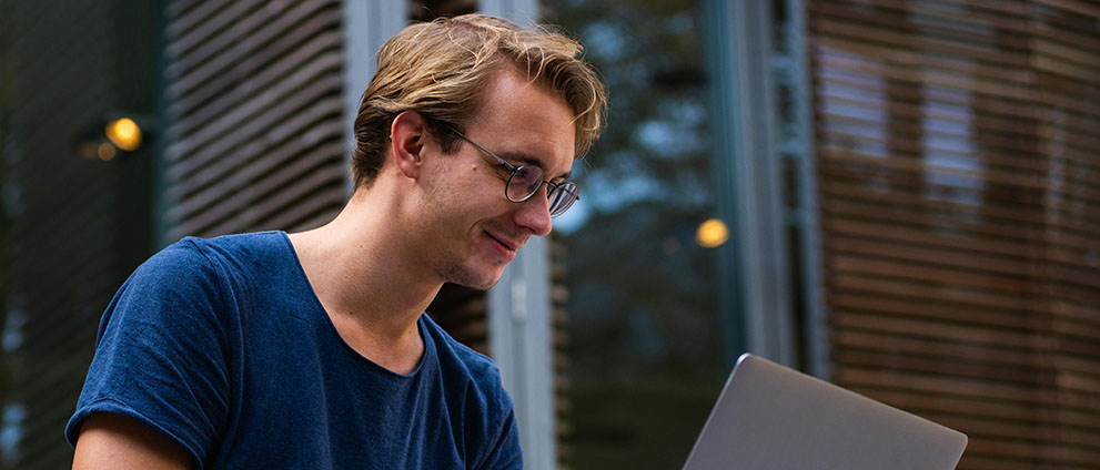 Młody chłopak pracuje na laptopie.