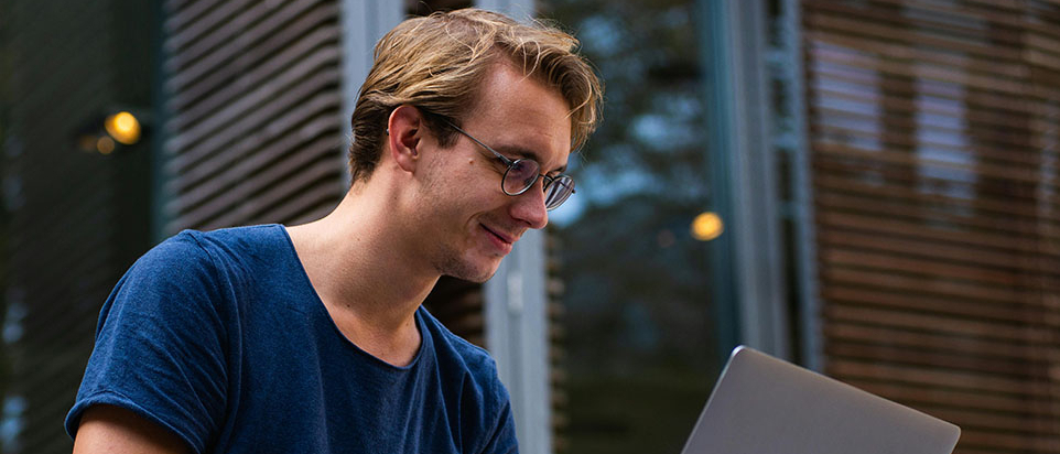 Młody chłopak pracuje na laptopie