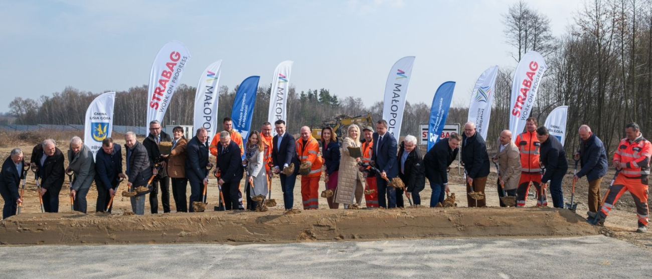 Uczestnicy wydarzenia wbijają symbolicznie łopaty w ziemię.