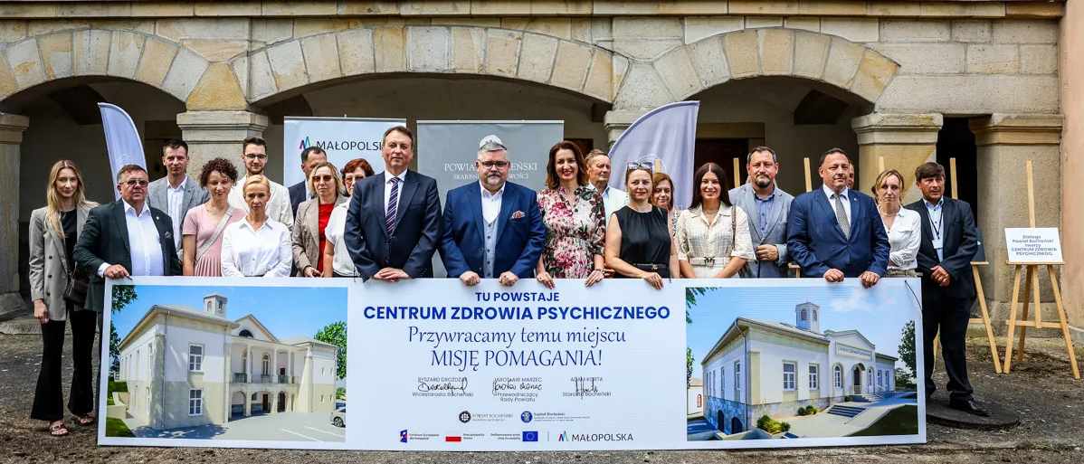 Uczestnicy wydarzenia z banerem : Tu powstaje Centrum Zdrowia Psychicznego. Przywracamy temu miejscu Misję Pomagania!