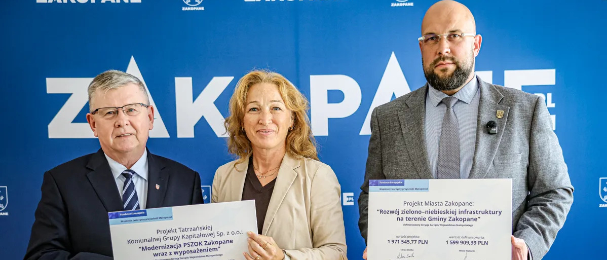 Wicemarszałek Witold Kozłowski, prezes tesko oraz burmistrz Zakopanego pozują z promesami.