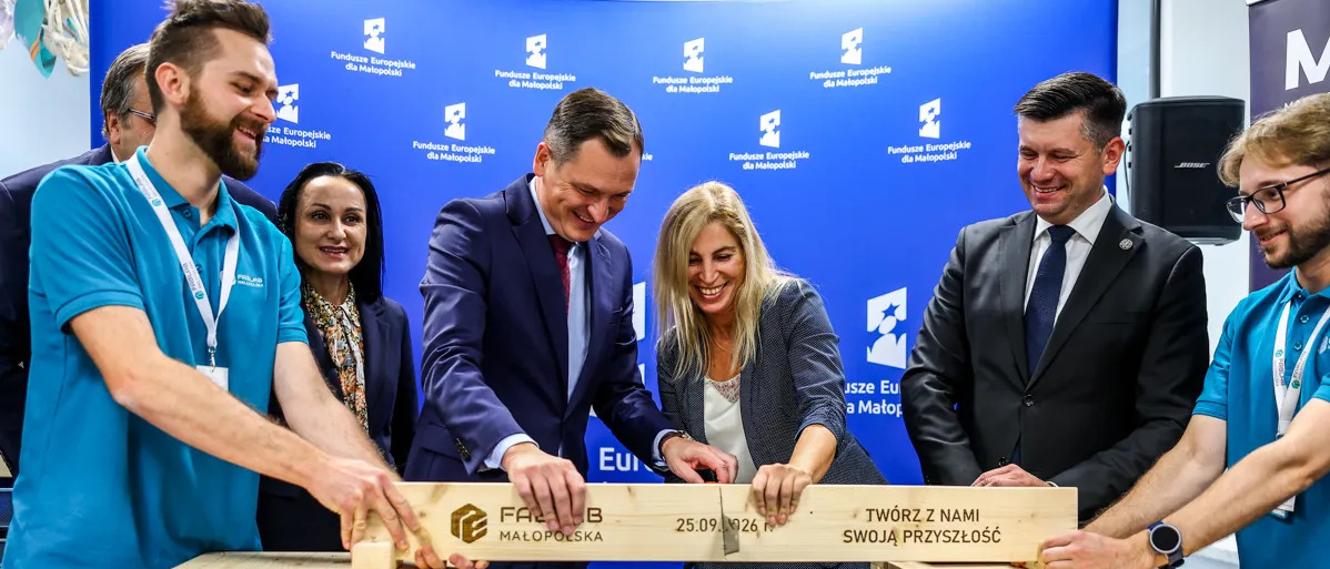 Symboliczne przecięcie deski z napisem Fablab Małopolska 25.09.2026, Twórz z nami swoją przyszłość. 